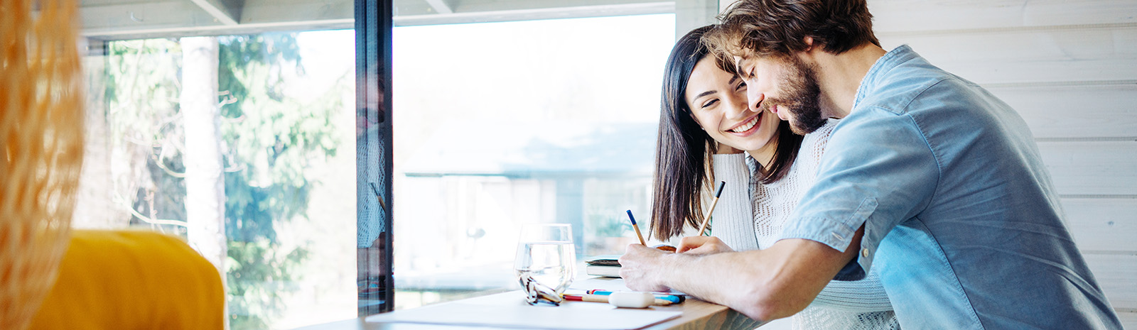 A woman and a man at a desk, holding pencils